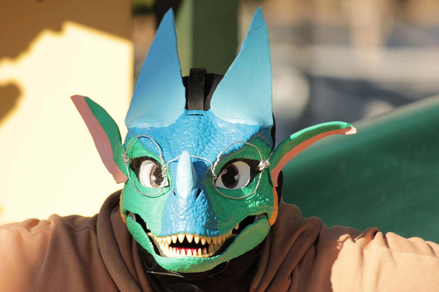 person in dragon mask green brown