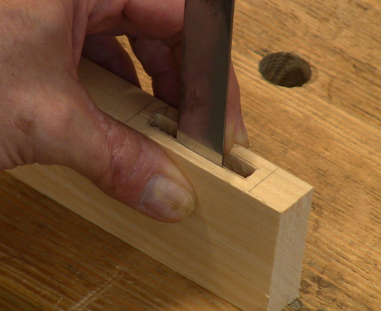 hand chiseling wood from a mortise