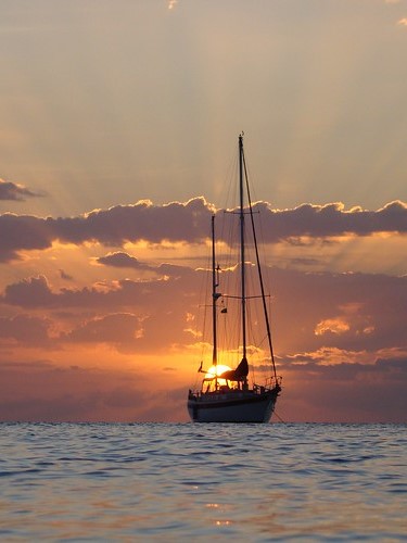 Sunset at sea with sail boat sillouette