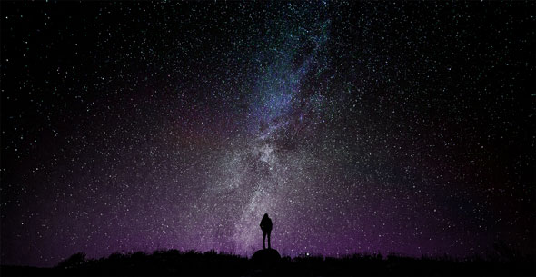 silohuette of a person looking into galaxy