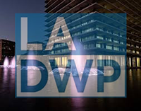 A low opacity L-A-D-W-P logo over the associated building and lit fountain at night