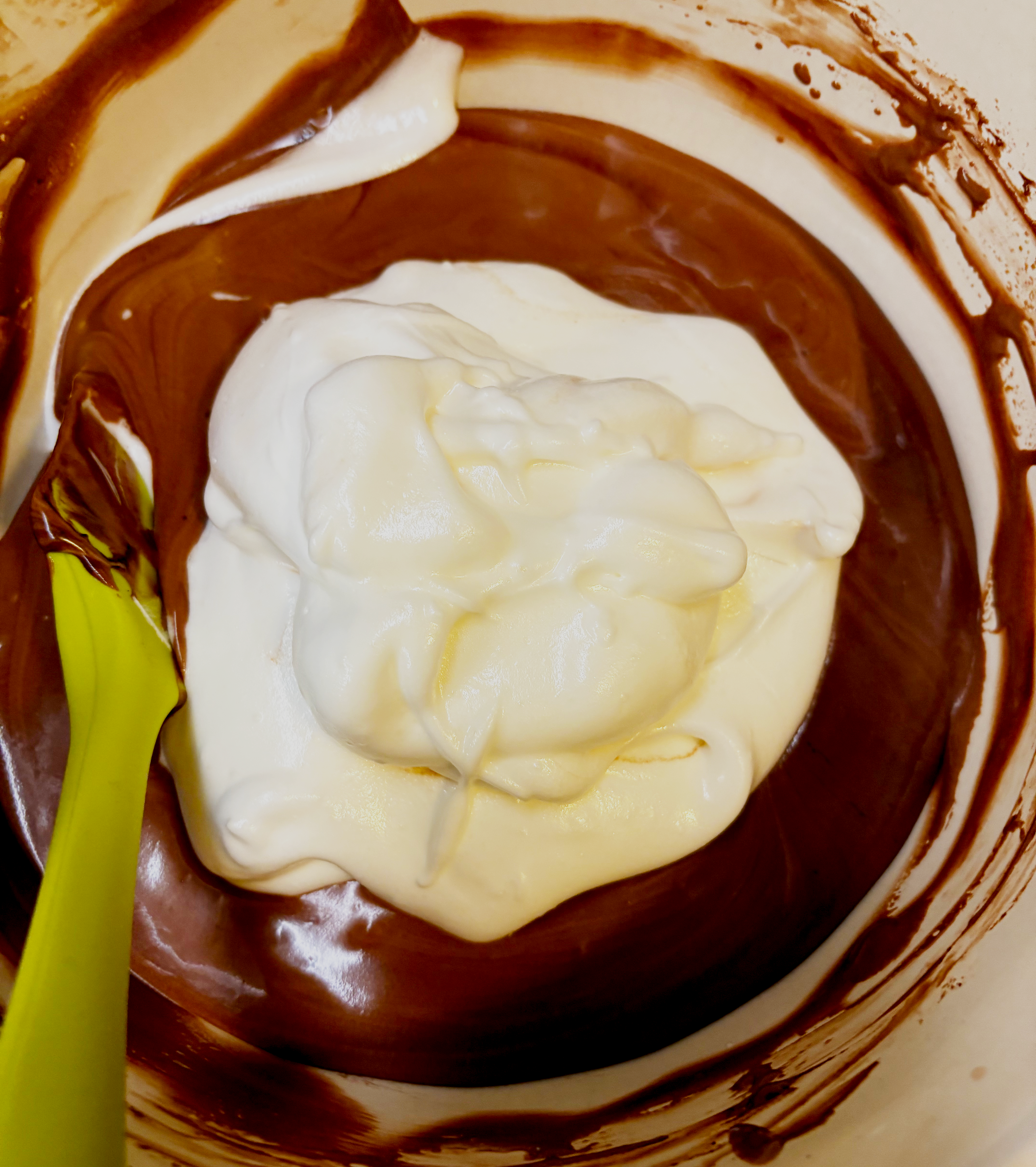 Starting to incorporate the meringue into the melted dark chocolate slowly.