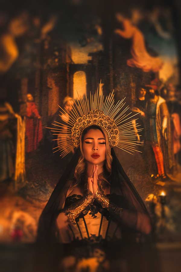 Mystical woman holding her hands together with her eyes closed