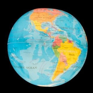 A brightly glowing globe of the world set against a black backdrop.