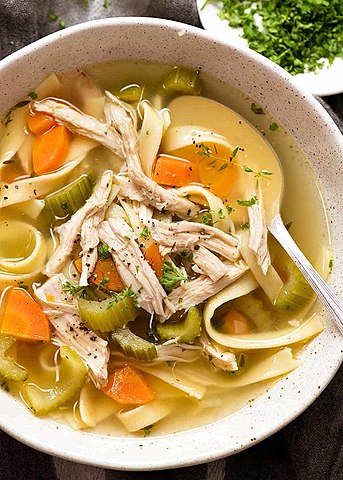 Top-down view of a bowl of chicken noodle soup