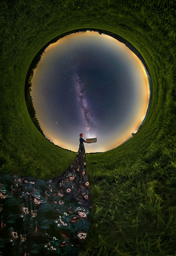 Mysterious woman with long dress looking up at starry night